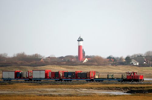 Inselbahn-Güterzug vor altem Leuchtturm